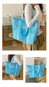 Blue mesh tote bag detail shot showing spacious shoulder strap and front pockets for travel.