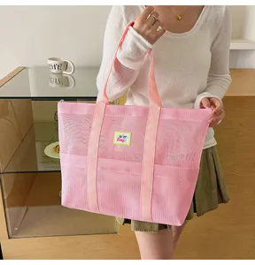 Pink mesh tote bag with double handles and front pocket, perfect for beach, travel, and daily use.