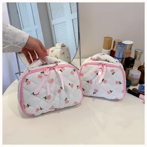 Quilted floral cosmetic bag with pink zipper, portable makeup organizer pouch for travel.