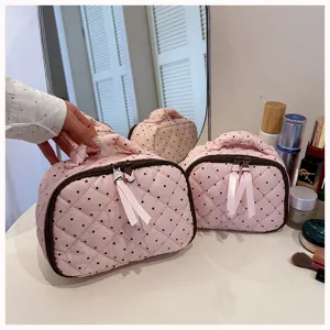Pink quilted polka dot cosmetic bag with cute bows, portable travel makeup storage pouch for women.