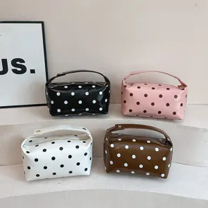 Minimalist PU leather polka dot cosmetic bag with handle, stylish travel makeup storage pouch.