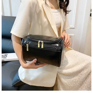 Black PU leather cosmetic bag detail showing portable handle and spacious interior storage.