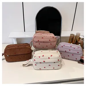 Corduroy strawberry cosmetic bag detail scene showing portable travel storage and cute design.