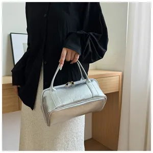 Silver leather cosmetic bag detail showing portable handle and premium metallic finish texture.
