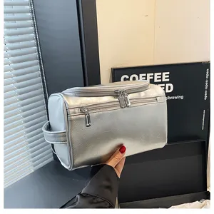 Detail view of the silver metallic PU leather cosmetic bag showing zipper and handle design.