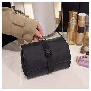 Vista dettagliata della borsa cosmetica pieghevole nera con fibbia e gancio di sospensione.