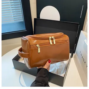 Premium brown PU leather cosmetic bag with multi-zippers and portable handle for travel use.