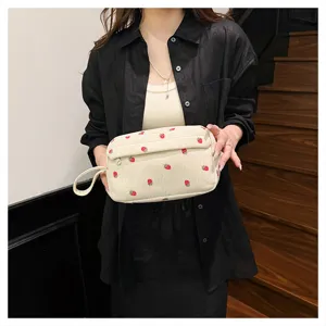 Corduroy strawberry cosmetic bag detail showing cute red fruit print and portable handle.
