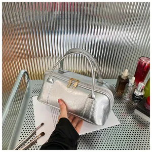 Silver metallic leather cosmetic bag detail showcasing dual metal zippers, sturdy handle and texture.