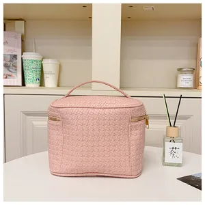 Pink PU woven cosmetic bag with handle and zipper, large capacity makeup storage bag for travel.