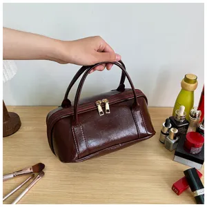 Dark red PU leather cosmetic bag, portable travel makeup organizer pouch with double zippers.