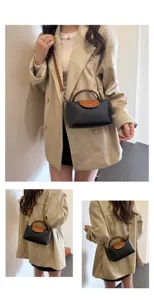 Chic black and brown leather dumpling crossbody bag for women, stylish top handle bag.