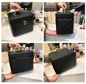 Black quilted makeup vanity case, portable leather cosmetic bag with sturdy metal handle.
