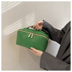 Elegante geweven cosmetische tas met grote opbergruimte en handig handvat voor reis.