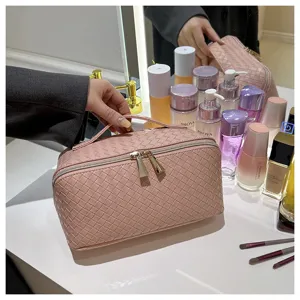 Gedetailleerd overzicht van roze geweven cosmetische tas met ritssluiting en handvat.