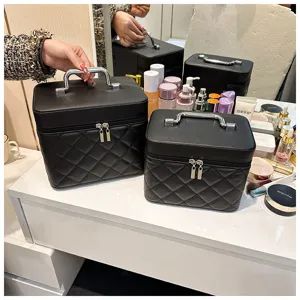 Detail view of portable black quilted cosmetic bag with silver handle and double zippers on vanity.