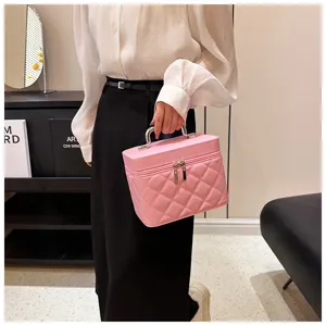 Pink quilted cosmetic bag with metal handle, portable travel makeup storage box for women.