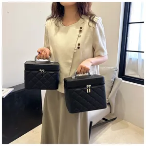Portable black quilted cosmetic bag with metal handle, stylish vanity case for daily travel.