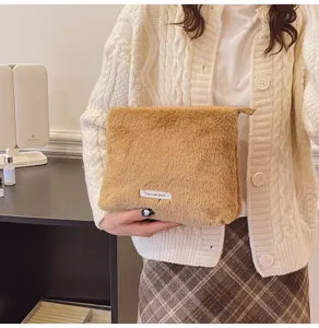 Fluffy cosmetic bag detail showing soft brown plush fabric and compact portable storage pouch.