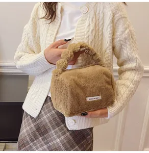 Close-up detail of a brown fluffy plush handbag, portable fluffy handle design for winter.