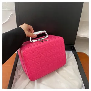 Pink cosmetic bag with quilted pattern and metal handle for travel storage details view.