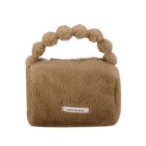 Cozy brown plush cosmetic bag for women, winter furry handbag with cute pom pom handle.