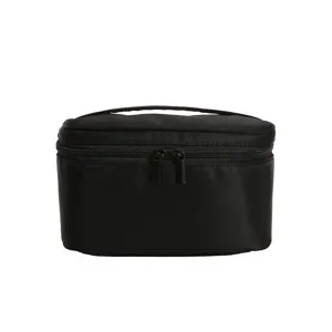 Zwarte stoffen cosmetische tas met dubbele rits en handvat voor reismake-upopslag.