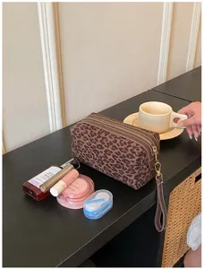 Detailed view of the retro leopard print cosmetic bag showing zipper and portable handle.