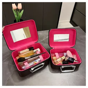 Detail view of the retro portable cosmetic train case featuring vibrant pink interior mirror.