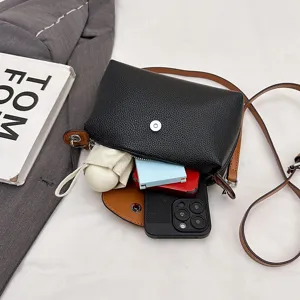 Black leather crossbody dumpling bag with brown strap, top view showcasing large capacity.