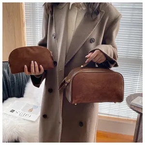 Brown suede cosmetic bag detail shot showing soft texture and premium double zipper design.