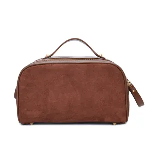 Brown suede cosmetic bag with top handle and spacious interior for travel and daily use.