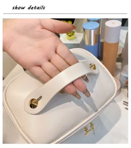 White PU leather cosmetic bag featuring gold pyramid studs, portable makeup storage detail.