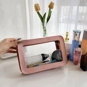 Clear TPU cosmetic bag with pink PU leather trim, portable travel makeup pouch organizer for women.