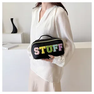 Black nylon cosmetic bag featuring colorful flocked letters and a convenient top handle.