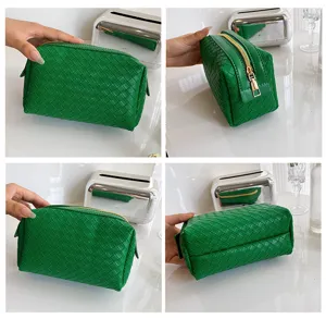 Green woven cosmetic bag close up details showing soft leather and smooth gold zipper.