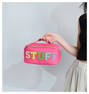 Nylon cosmetic bag detail showing colorful fluffy letter patches and spacious zipper design.