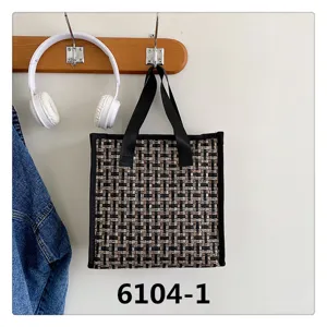 Detailed view of vintage tweed tote bag, elegant woven fabric pattern, daily shoulder accessory.