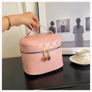 Pink PU leather cosmetic bag with chic checkerboard embossing and gold zipper closure.