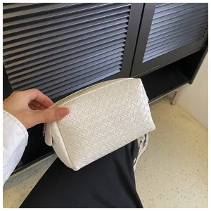 White woven leather cosmetic pouch, detail view of the elegant intrecciato design.