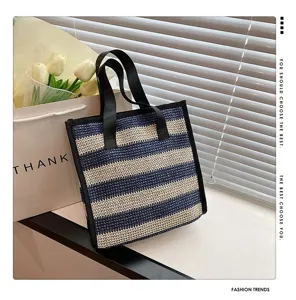 Vista dettagliata della borsa cosmetica in paglia a righe blu e bianche con trama pulita.