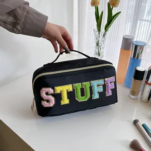 Black nylon cosmetic bag with colorful fuzzy letter patches, portable handle and large capacity.