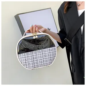 Detail shot of the round cosmetic bag featuring chic tweed and patent leather finish.