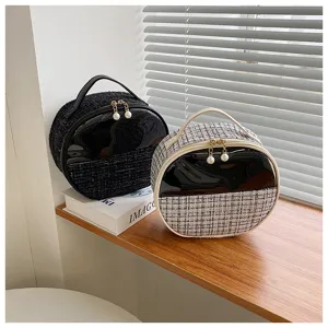 Round tweed cosmetic bag with patent leather and pearl zip for daily travel and makeup storage.
