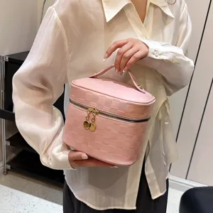 Pink PU leather cosmetic bag with top handle and gold zipper, stylish travel makeup organizer.