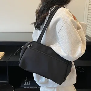 Détail du sac bandoulière en nylon noir minimaliste, grand cabas quotidien décontracté.