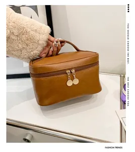 Detail view of brown PU leather cosmetic bag, large capacity travel toiletry organizer.