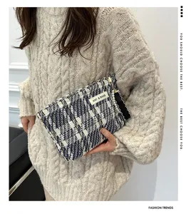 Chic tweed cosmetic bag with pearl pendant, stylish stripe clutch for women daily use.