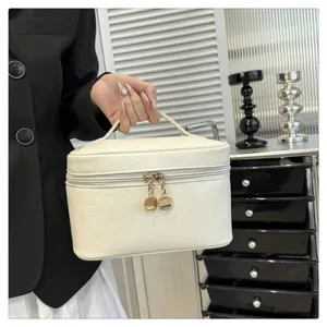 Minimalist solid color PU leather cosmetic bag detail view, featuring durable handle and gold zippers.