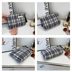 Close-up detail view of the classic tweed cosmetic pouch, showing textured fabric and zipper.